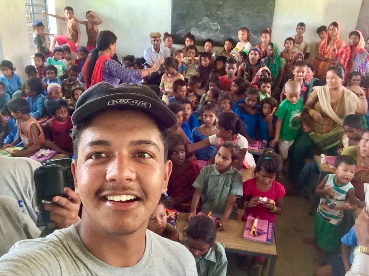 Rasil taking a selfie with students during a Book For A Cause library visit