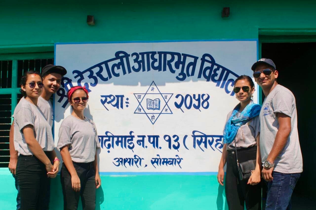 Students and volunteers around a Book For A Cause library collection