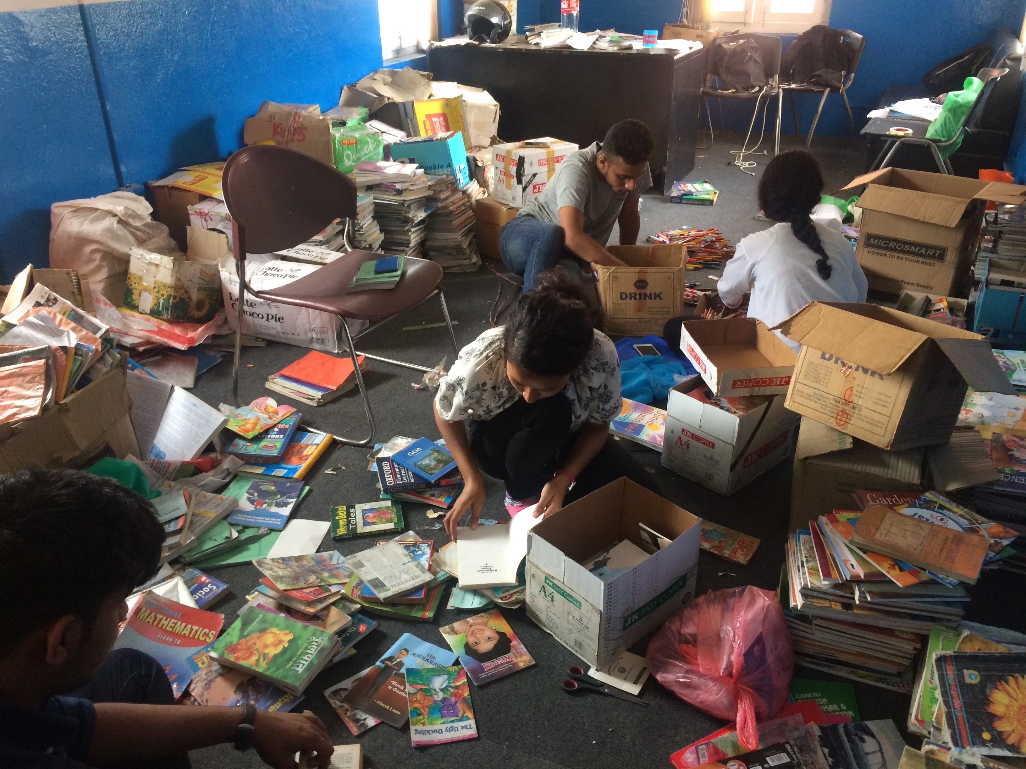 Volunteers sorting donated books and school supplies in the Book For A Cause office
