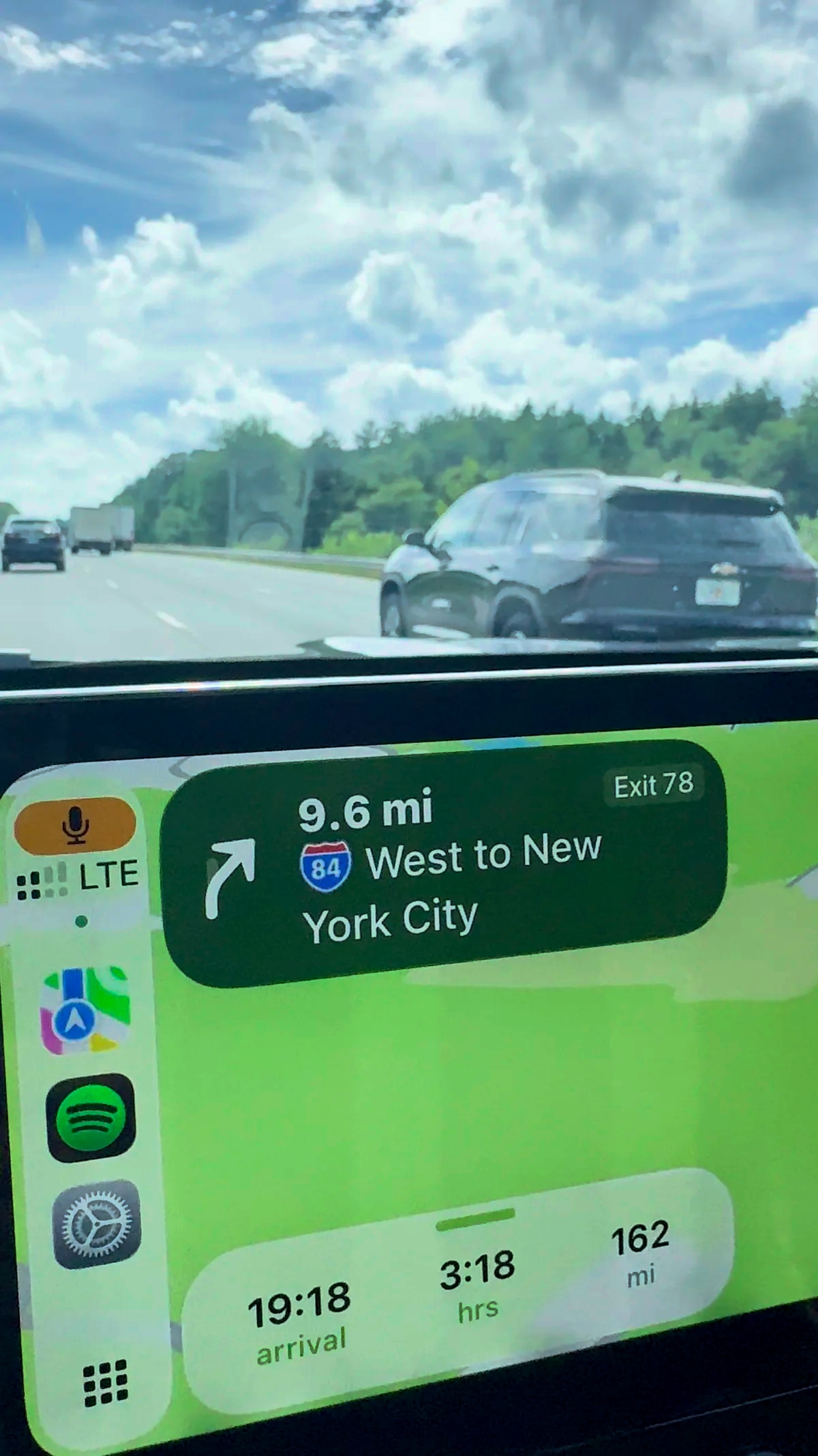 Apple CarPlay navigation showing I-84 West to New York City, with highway traffic visible through the windshield.