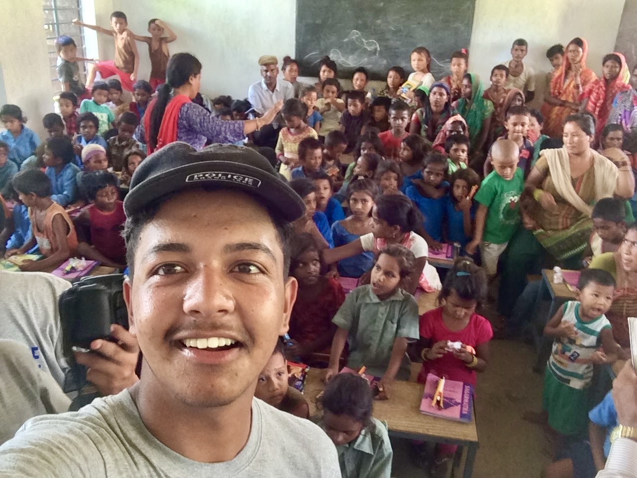 Rasil taking a selfie with students during a Book For A Cause library visit